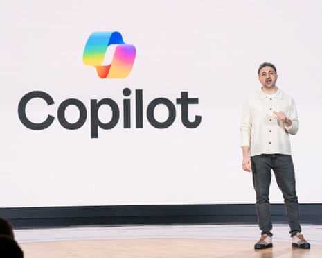 a man speaks onstage in front of a backdrop that says 'copilot'