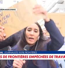 A repórter Anaïs Maréchal se desvencilha dos cartazes colocados à sua frente para tentar trabalhar Foto: Reprodução