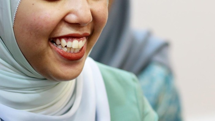Young Muslim woman is feeling cheerful at home.