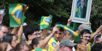 Apoiadores de Fl&aacute;vio Bolsonaro acenam com bandeiras do Brasil e quadro de Jair antes de carreata em Santa B&aacute;rbara d'Oeste Foto: Felipe Rau/Estad&atilde;o