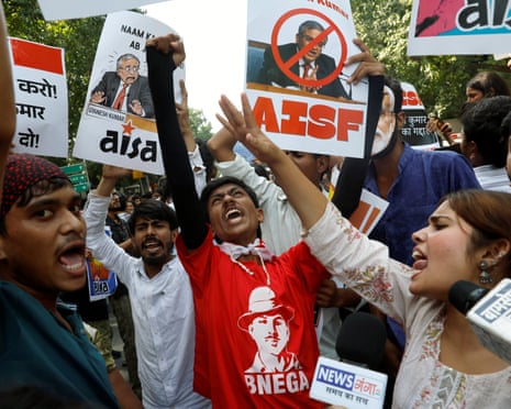 Protesters shout, holding signs demanding Election Commissioner Gyanesh Kumar's resignation